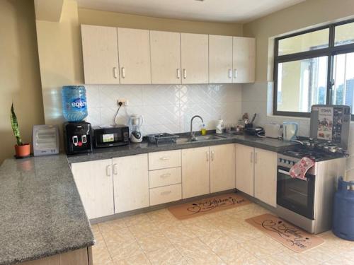 a kitchen with white cabinets and a counter top at Floma Homes in Nairobi