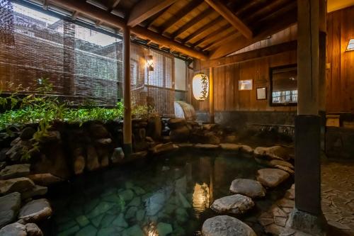 a pool in the middle of a house with rocks in it at 岩井温泉　岩井屋 in Iwamicho