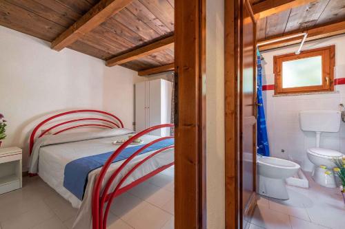 a bedroom with a bed and a toilet and a sink at Apartment in San Teodoro 23143 in San Teodoro