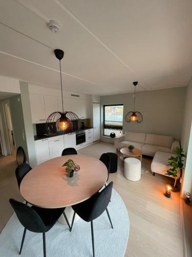 a living room with a table and chairs and a couch at New Powerhouse apartment in Lade in Trondheim in Trondheim