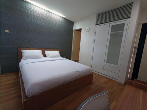 1 dormitorio con 1 cama grande con sábanas blancas en FLAT06 cipete, en Yakarta