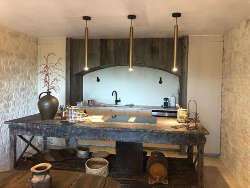- une cuisine avec un grand comptoir en pierre et un évier dans l'établissement Charmant gîte de 4 à 6 personnes à 5km de Duras, à Savignac-de-Duras