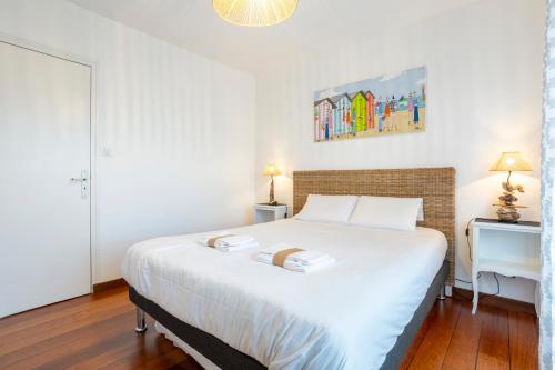 a bedroom with a white bed with two towels on it at La Baie - vue sur la plage in La Forêt-Fouesnant