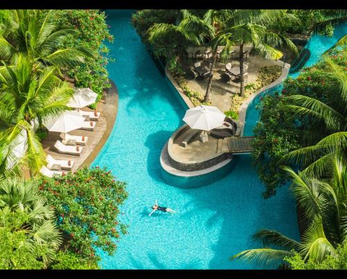 an aerial view of a pool with a person in the water at DoubleTree by Hilton Jakarta - Diponegoro in Jakarta