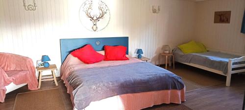 Schlafzimmer mit einem Bett mit roten und grünen Kissen in der Unterkunft Gite Puydufou -5kms- La Séraphina, 2 à 6 personnes in Chambretaud