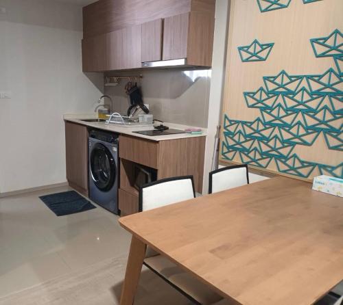 a kitchen with a washing machine and a table with chairs at La Casita Hua-Hin By 95 Group in Hua Hin