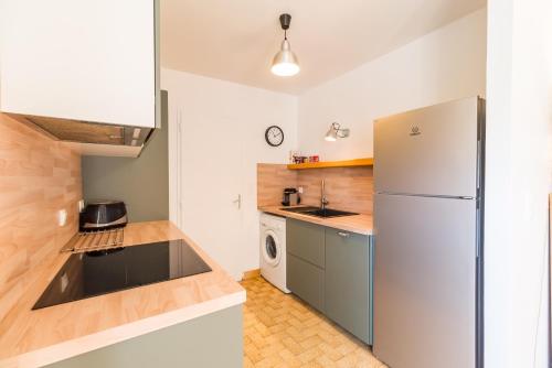 a kitchen with a refrigerator and a washer and dryer at Ar Pazenn - Découverte de la côte de granit rose in Plouguiel