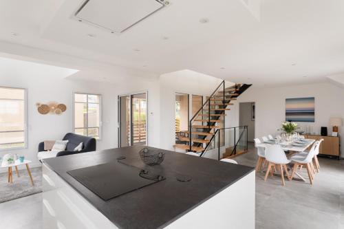 d'une cuisine et d'un salon avec un escalier en arrière-plan. dans l'établissement Villa Calypso - Vue mer à Saint-Lunaire, à Saint-Lunaire