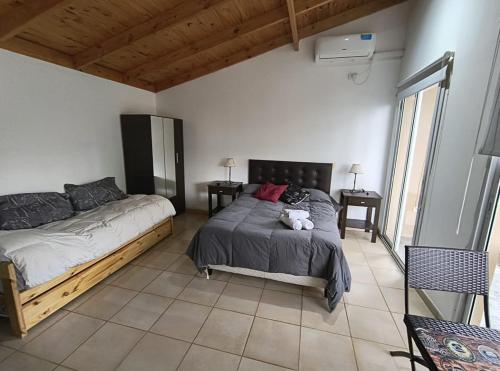a bedroom with two beds and two tables and windows at Cabañas bahia in Bahía Blanca