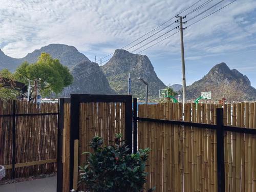 a wooden fence with mountains in the background at Serene Vale Inn Railway station free pick-up by 2 nights English and Spanish reception available in Guilin