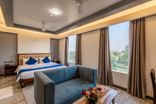 ein Hotelzimmer mit einem Bett und einer blauen Couch in der Unterkunft Clarks Inn Suites Jaipur in Jaipur