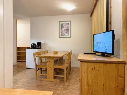 une cuisine et une salle à manger avec une table et une télévision dans l'établissement Les Chalets de la Vanoise Appartement, à Villarodin-Bourget