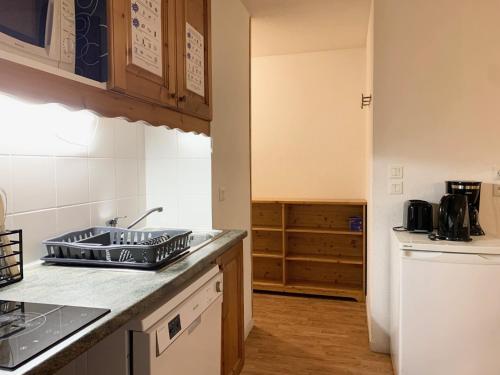 une cuisine avec un évier et un plan de travail dans l'établissement Les Chalets de la Vanoise Appartement, à Villarodin-Bourget