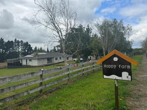 a happy farm sign in front of a fence at Family house in happy farm in Pokeno