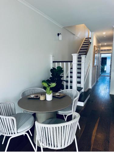 a dining room with a table and chairs and a staircase at Noosa Waters Retreat in Noosaville