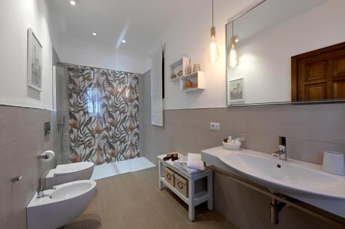 a bathroom with two sinks and a toilet and a shower at Bilocale Il Nido in Massa Lubrense