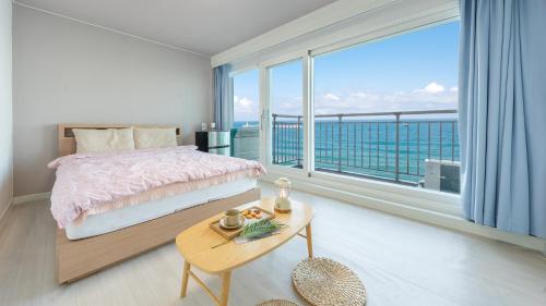 ein Schlafzimmer mit einem Bett und einem großen Fenster in der Unterkunft Gangneung Haerang Pension in Gangneung