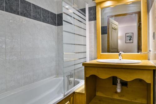 une salle de bain avec un lavabo, une baignoire et un miroir dans l'établissement Résidence Les Hauts De Preclaux - Charmant studio tout proche des commerces MAE-8041, aux Orres