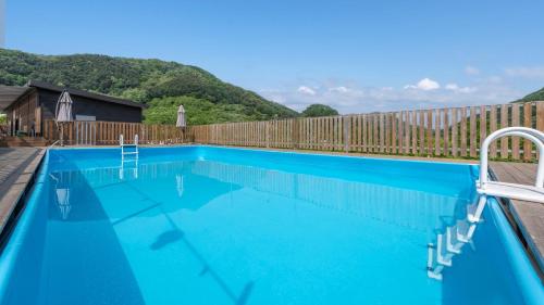 a blue swimming pool with a wooden fence at Gapyeong Sanmaeul Glamping in Gapyeong