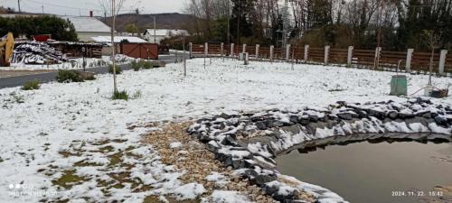 a snow covered yard with a stone bridge at Aba-Böbe Vendégház in Zalaszentiván
