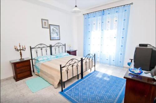 - une chambre avec un lit, une commode et une télévision dans l'établissement B&B Casa Rosino, à Dolianova