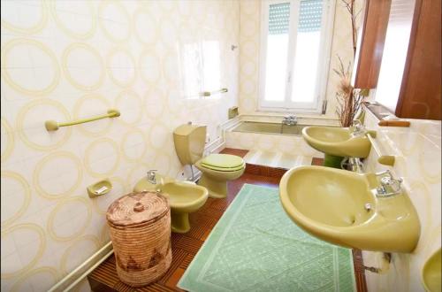 La salle de bains est pourvue de 2 lavabos, de toilettes et d'une baignoire. dans l'établissement B&B Casa Rosino, à Dolianova