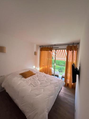 un lit dans une chambre avec une grande fenêtre dans l'établissement Appartement entièrement rénové dans le centre de Saint Tropez, à Saint-Tropez