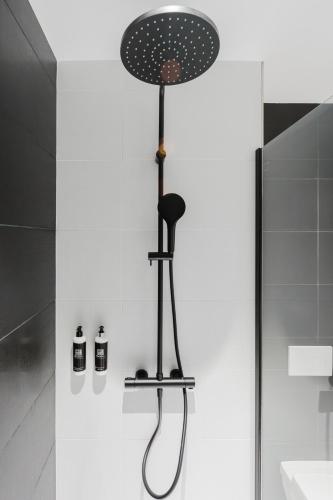 a shower in a bathroom with a shower head at Les Lodges de Socrate in Le Vaudreuil