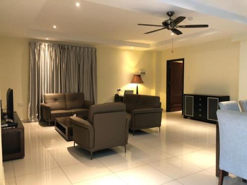 a living room with furniture and a ceiling fan at Palm Beach Hotel Dili in Dili