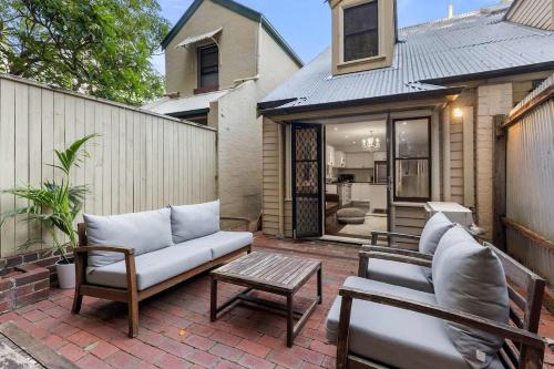 a patio with a couch and chairs and a table at Perfect Vacation Home w Large Outdoor Space in Sydney