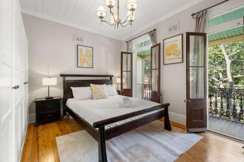 a bedroom with a bed and a chandelier at Perfect Vacation Home w Large Outdoor Space in Sydney