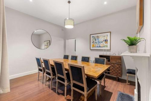 a dining room with a wooden table and chairs at Perfect Vacation Home w Large Outdoor Space in Sydney