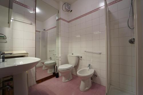a bathroom with two toilets and a sink and a shower at Villa Adelaide 22 Pax by VILLASRETREATS in Rometta