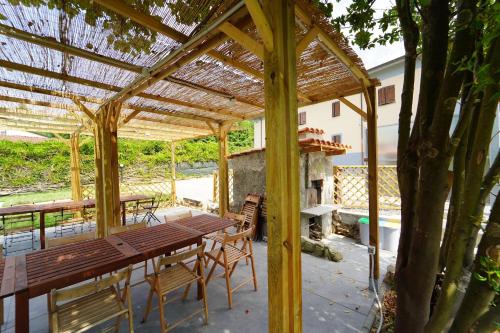 a wooden table and chairs under a pergola at Villa Adelaide 22 Pax by VILLASRETREATS in Rometta
