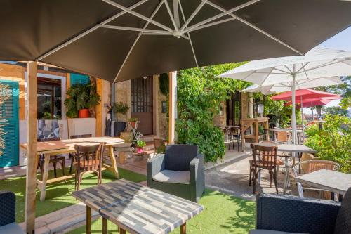 an outdoor patio with tables and chairs and umbrellas at Logis Hôtel Beauséjour in Berre-les Alpes
