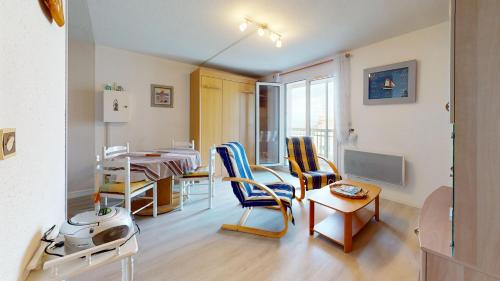 una sala de estar con una mesa y sillas en Cap a L Ouest, en Les Bussolleries