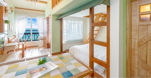 a bedroom with a bunk bed and a view of the ocean at Ganghwa hana & alice spa pension in Incheon