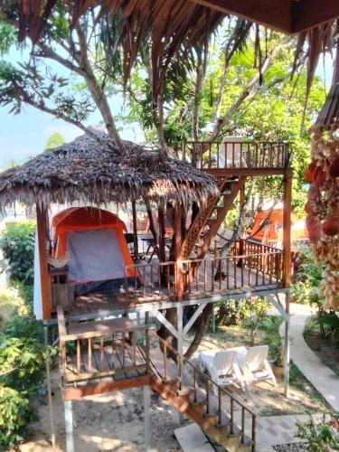 a tree house with a deck and chairs at Rommai Forest Bungalows in Ko Lanta