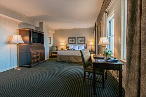 a hotel room with a bed and a desk at The Brown Hotel in Louisville