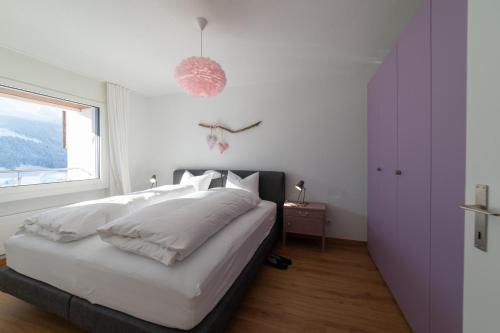 a bedroom with a bed with white sheets and a window at Panorama Blick in Unterwasser