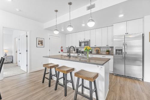 eine Küche mit weißen Schränken und eine große Insel mit Barhockern in der Unterkunft Blue Horse #203 condo in Hurricane