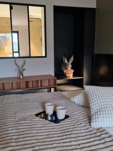 a tray with two cups on top of a bed at Les Lodges de Socrate in Le Vaudreuil