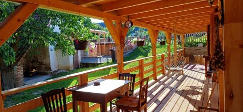 a wooden porch with a table and chairs on it at Chalupa Pod třešní in Desov