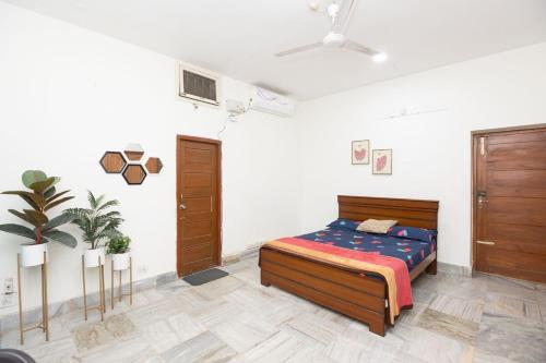 a bedroom with a bed and a plant in it at DestinationHomes-LiveScreen-Ameerpet in Hyderabad