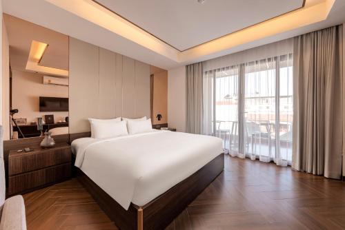 ein Schlafzimmer mit großem Bett und großem Fenster in der Unterkunft Riverside Hotel in Vientiane
