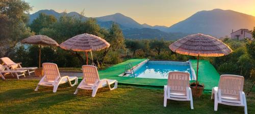 a group of chairs and umbrellas next to a pool at Villa - Malibu' B & B in Lauria
