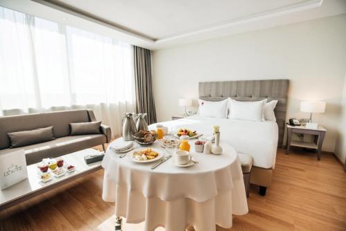 a hotel room with a bed and a table with food on it at Grand Mogador City Center in Casablanca