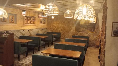 a restaurant with wooden tables and chairs and chandeliers at Logis Hôtel Beauséjour in Berre-les Alpes
