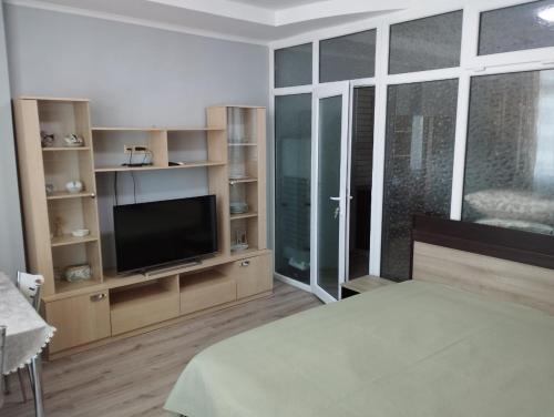 a bedroom with a bed and a flat screen tv at Yalcin Star Residence Apartment 300 in Batumi