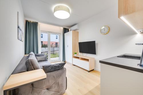 a living room with a couch and a tv at ReVital Mechelinki by Homeprime Parking Free in Mechelinki